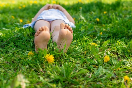 child feet in a garden with dandelions. Selective focus. kid,