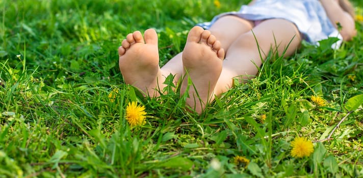 child feet in a garden with dandelions. Selective focus. kid,