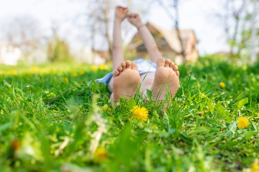 child feet in a garden with dandelions. Selective focus. kid,