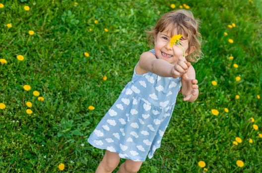 Child in the garden with a bouquet of dandelions. Selective focus. Kid.