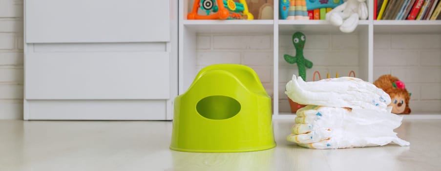 Green potty and toilet paper in the room