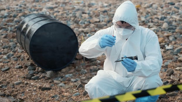 Ecologist sampling water from the river to water quality tester and peek into, Biologist wear protective suit and mask collects sample of waste water from industrial for pH meter, problem environment