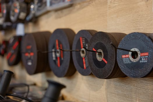 Hardware store display with abrasive cutting wheels. Different kinds of spare parts for grinding machine. Round discs for power circular saw wide shop assortment