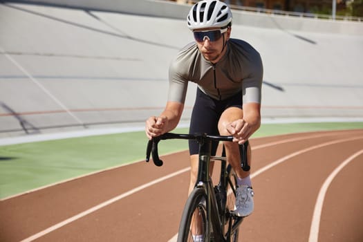 Bicyclist holding hands on steering wheel driving bike. Sportsman practicing alone on velodrome enjoying extreme speed riding