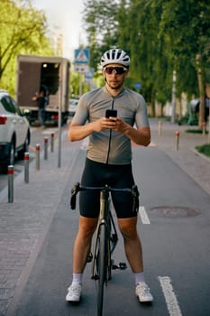Serious man bicyclist riding along bike path on urban street. Cyclist moving through city roads using special place for bicycle driving. Traffic laws for cycle riders