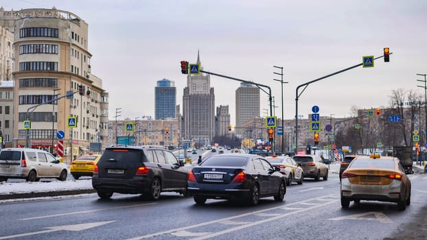Urban traffic moving on a winter day in Moscow, Russia, featuring the iconic Ministry of Foreign Affairs skyscraper