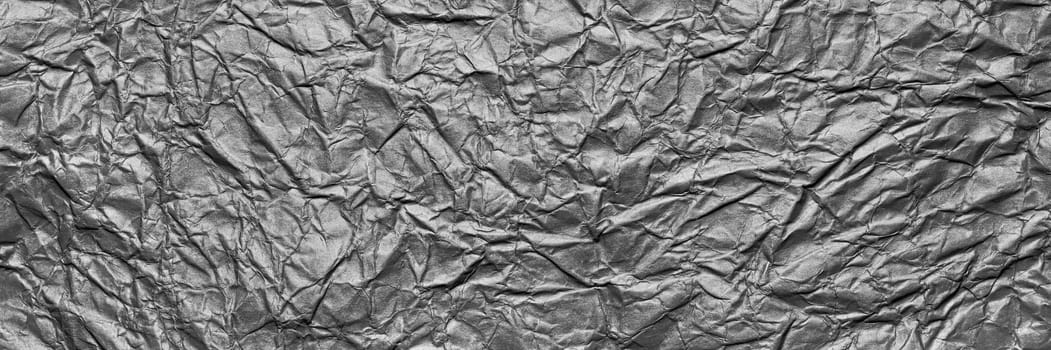 A textured gray crumpled paper background with natural creases and folds. Ideal for design projects, digital graphics, or creative presentations requiring a vibrant, Long banner.