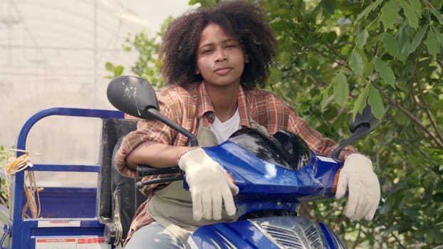 Happy children girl farmer sitting on tricycle in hydroponics farm, Biotechnology kid with Skylab motorcycle at vegetable farm, market transportation