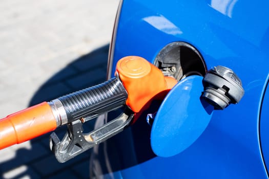 A gas pump is securely attached to the side of a shiny blue car, ready to provide fuel for the vehicles journey ahead