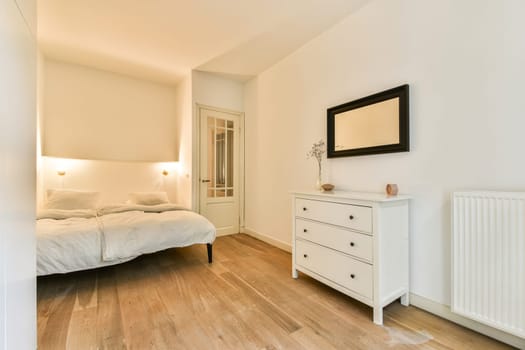 A serene and minimalist bedroom featuring a neatly made bed, a stylish dresser, and warm lighting that creates a tranquil atmosphere.