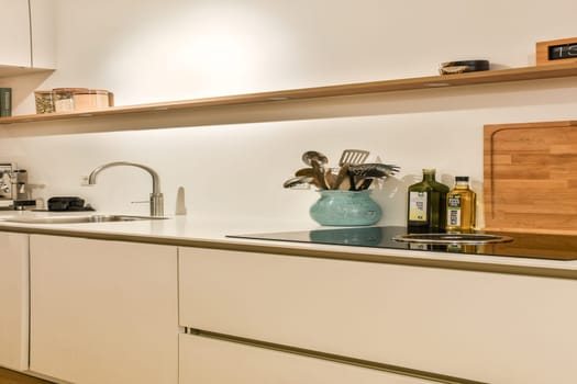 Sleek and contemporary kitchen featuring minimalist cabinetry, stylish utensils, and a clean countertop setup. Ideal for modern home aesthetics.