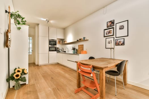 This sleek kitchen features modern appliances, wooden dining furniture, and minimal decor, creating a warm yet stylish atmosphere that invites comfort.