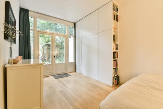 A spacious and bright modern bedroom featuring minimalist decor, natural light through large windows, and soothing wooden flooring, creating a serene atmosphere.