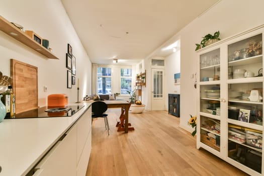 A bright and spacious modern interior featuring wooden flooring, sleek furniture, and large windows that invite natural light, creating an open and inviting atmosphere.