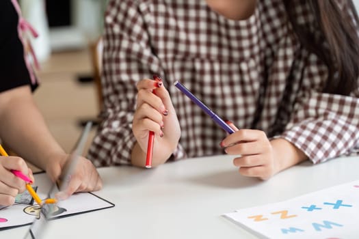 Students engaged in creative activities, drawing and coloring on worksheets while preparing for the new school year, showcasing collaboration and artistic expression.