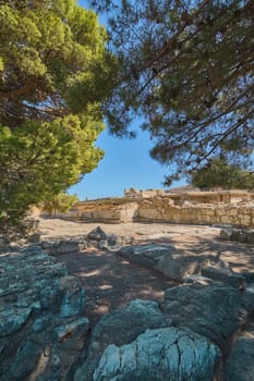 Crete.Greece - april 24, 2025: This photograph captures Knossos' archaeological site, highlighting stone structures beneath a bright blue sky. The setting emphasizes the historical significance