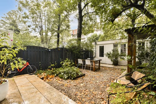 A tranquil garden space featuring a variety of greenery, seating area, and a bicycle, perfect for relaxation and outdoor gatherings.