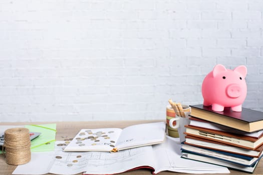 A piggy bank placed atop a pile of stacked books effectively symbolizes the concepts of savings and financial education