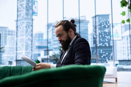 Young business director reviews sales trends and budget reports in his smart office, ensuring profitability and company success through effective decision making and strategic planning.