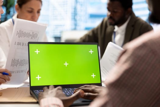 Business associates in a meeting using isolated chroma key display, working on resource allocation plans to increase profit. Team of corporate employees in a project briefing. Close up.