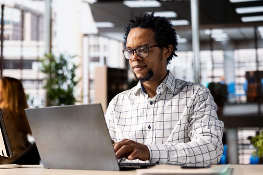 Successful entrepreneur working on financial forecasts at his desk, using data and technology to manage business tasks and project development. Company progresses toward its goals.