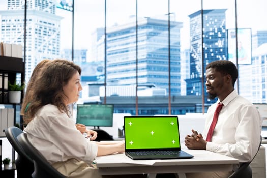 Team of HR experts negotiating job offers and salary packages with candidate, using green screen laptop. Colleagues analyzing applicant resume and cover letter, using mockup notebook