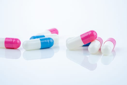 Blue and pink capsule pills spread on white background, showcasing pharmaceutical products, healthcare concepts, and the role of prescription medicine in advancing treatment and patient well-being.