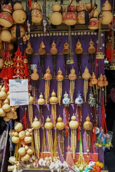 Shanghai, China - 2 April 2025: Colorful display of traditional Chinese hulusi wind instruments and souvenir gourds at a Yunnan Old Street market stall, featuring hand-painted dragon designs and red tassels