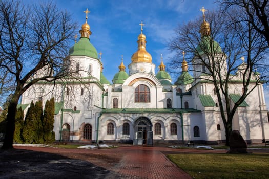 Saint Sophia Cathedral in Kyiv Ukraine showcases beautiful architectural elements and golden domes under a clear blue sky. This orthodox cathedral is a historic landmark, drawing many visitors daily.