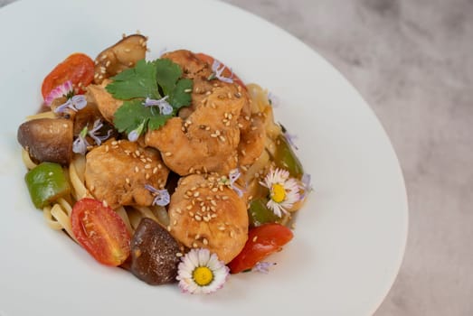 A flavorful blend of chicken, linguine, shiitake mushrooms, bell peppers, and fresh garden flowers offers a vibrant and appetizing meal. Ideal for a cozy dinner or gathering.
