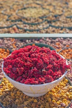 High angel view of bowl full of red dried flowers in a market in Marrakech. Morocco. Vertically. 