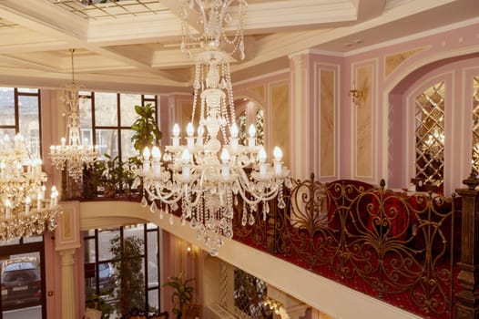 Odessa, Ukraine - February 26, 2025: Hotel California. Luxurious hotel lobby with a large crystal chandelier and interior design in red and gold tones