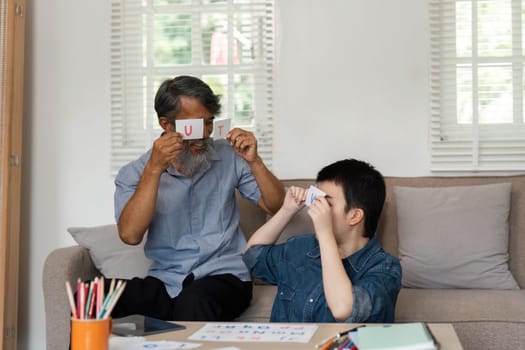 The grandfather and his grandson share a playful learning experience, focusing on letters and sounds while strengthening their family bond.