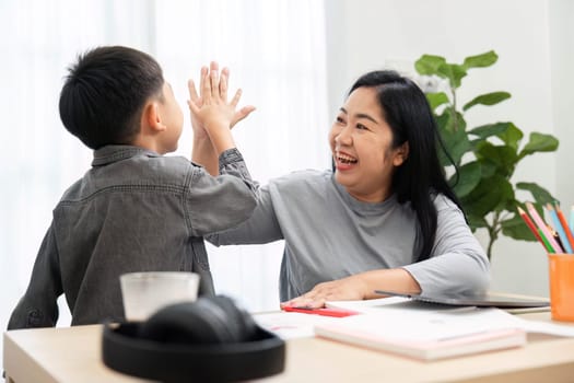 A cheerful mother and her son celebrate their back-to-school preparations with a high-five, showcasing their close relationship and excitement for the upcoming school year.