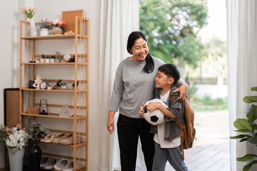 A mother and her son share a joyful moment before heading to school, highlighting the importance of family connection and support in a child's life.