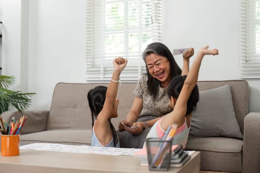 The grandmother joyfully engages with her granddaughters as they celebrate their artistic achievements, enhancing their learning experience together.