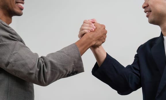 Two men shake hands, signifying a successful collaboration or agreement in a business context, showcasing professionalism and mutual respect.