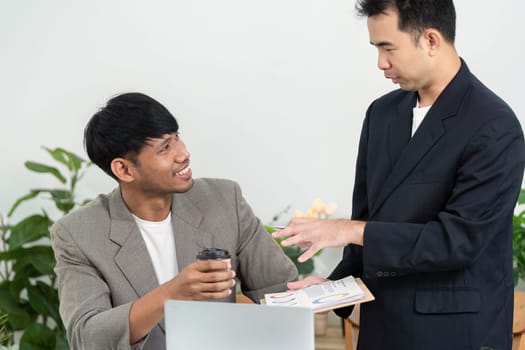 Two colleagues engage in a productive discussion, sharing insights and strategies while enjoying coffee in a contemporary workspace.