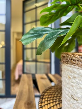Balcony relax area with garden furniture, green flower, boho style, wood chair, bloor window, real photo