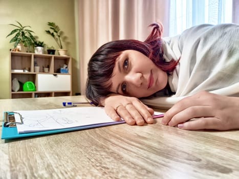 Psychologist takes a moment to contemplate patient notes while working in her cozy office, fostering a calming environment for therapy.