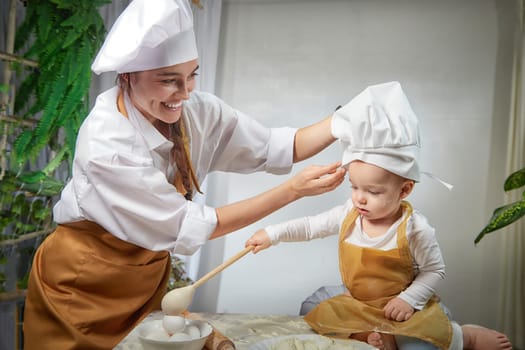 A family enjoys a fun cooking session, playfully covered in flour while engaging with their little ones in warm kitchen. Mother and son having fun