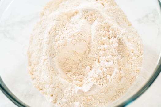 Close-up of a large bowl filled with flour, prepared for the Chocolate Ginger Sugar Cookie Dough, showing the smooth texture of the dry ingredients.