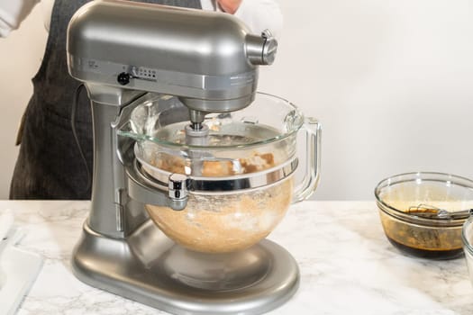 A stand mixer being used to combine ingredients for Chocolate Gingerbread Cookie Dough. The mixing process is underway, creating a rich and smooth cookie dough.
