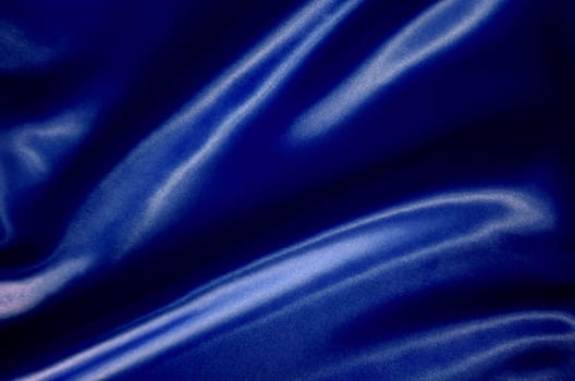 Top view of dark blue silk cloth with silky sheen suitable for design and wallpaper background.