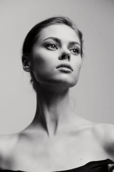 Striking black and white portrait of a young woman with an introspective gaze, highlighting her elegant features and minimalist style. Perfect for beauty and fashion themes.