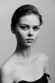Sophisticated black and white portrait of a young woman with smooth skin and defined cheekbones, reflecting poise and inner strength.