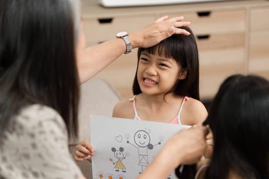 The grandmother supports her granddaughter by appreciating her artwork, fostering creativity and connection in a loving family environment.