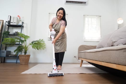 A mother focuses on vacuuming the living room, emphasizing the importance of cleanliness and family participation in household tasks.