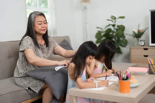 A warm moment captured as a grandmother assists her granddaughters in their artistic pursuits, promoting learning and creativity.