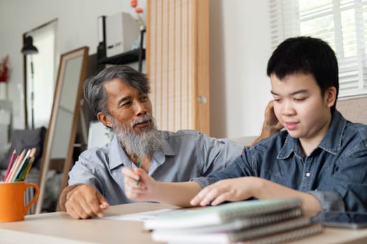 In a warm home setting, a grandfather supports his grandson in drawing activities, nurturing creativity and strengthening their bond through shared artistic experiences.
